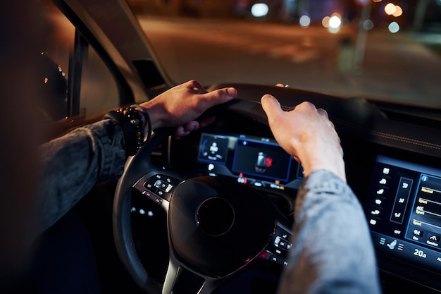 Uomo bello con la barba lunga in abiti alla moda che guida la sua automobile