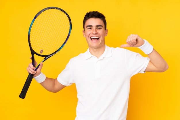Uomo bello del tennis dell'adolescente isolato su giallo
