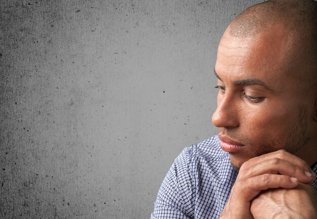Uomo bello depresso isolato su sfondo grigio muro