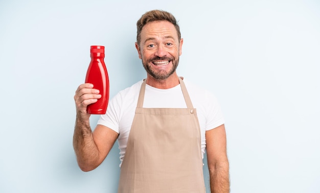 Uomo bello di mezza età che sembra felice e piacevolmente sorpreso. concetto di ketchup