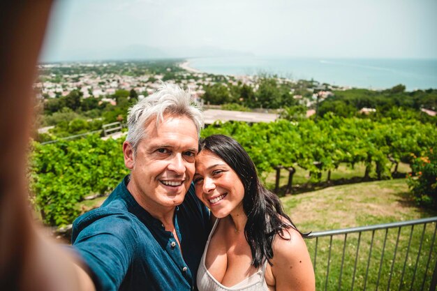 Uomo bello e bella ragazza innamorata che si diverte genuinamente prendendo selfie in un tour della città di paesaggio marino Concetto di vacanza di viaggio stile di vita Wanderlust con coppia di turisti in visita alla città di mare