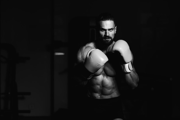 Uomo bello in guantoni da boxe gialli Boxe in palestra Il concetto di uno stile di vita sano L'idea per il film sulla boxe