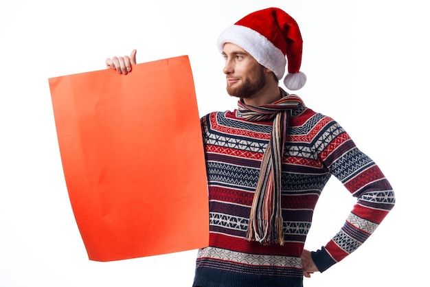 Uomo bello in un cappello di natale con lo studio copyspace del manifesto rosso del mockup