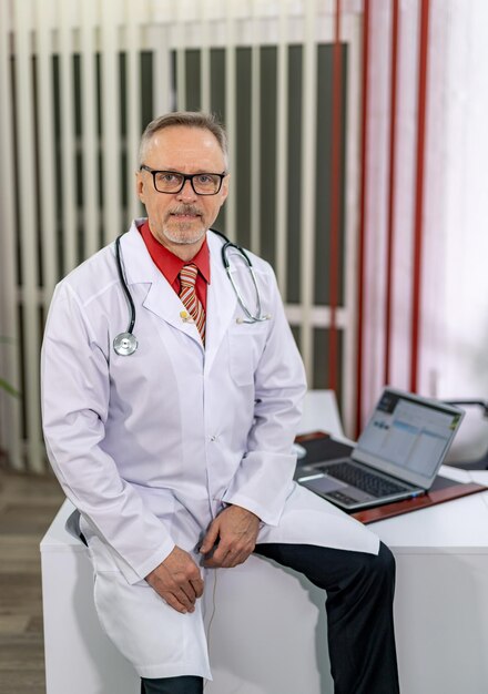 Uomo bello in uniforme medica. Dottore con gli occhiali in posa per la macchina fotografica.