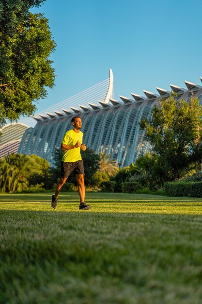 Uomo bello ispanico che fa jogging nel giardino della città delle arti e del parco delle scienze Valencia Spagna