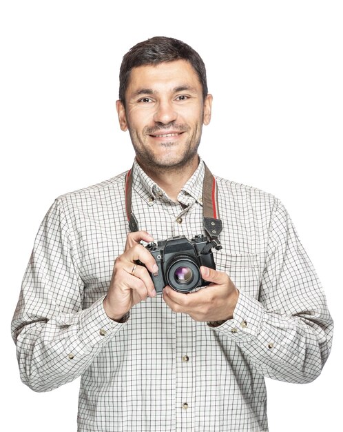 Uomo bello positivo in camicia a quadri, sorridente e scattare foto con la fotocamera vintage