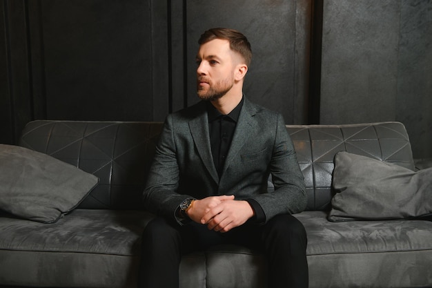 Uomo bello rispettabile in abito elegante in appartamenti con interni lussuosi classici bellezza maschile moda