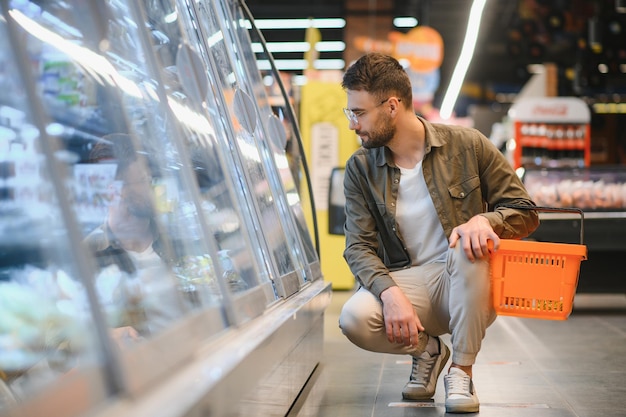 Uomo bello shopping in un supermercato