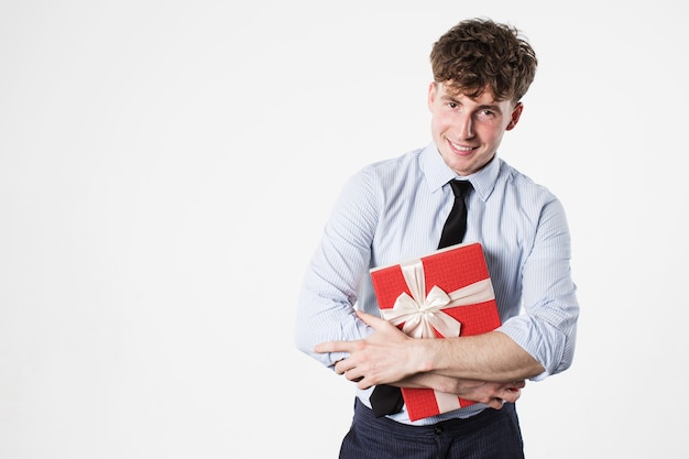 Uomo bello sorridente con una confezione regalo