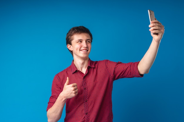 Uomo bello sorridente positivo con un telefono cellulare