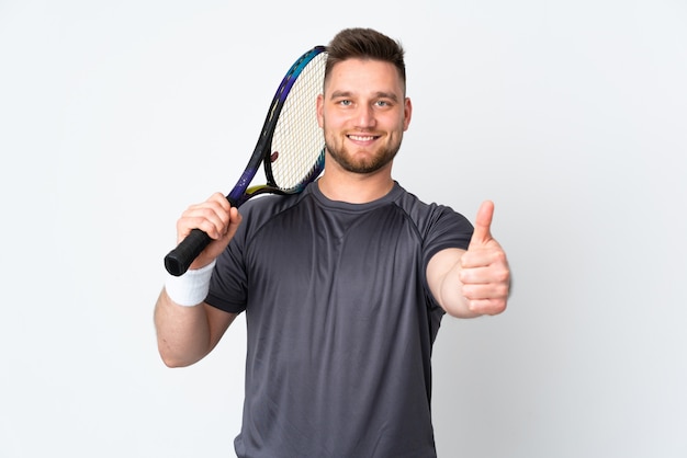 uomo bello sulla parete bianca che gioca a tennis e con il pollice in su