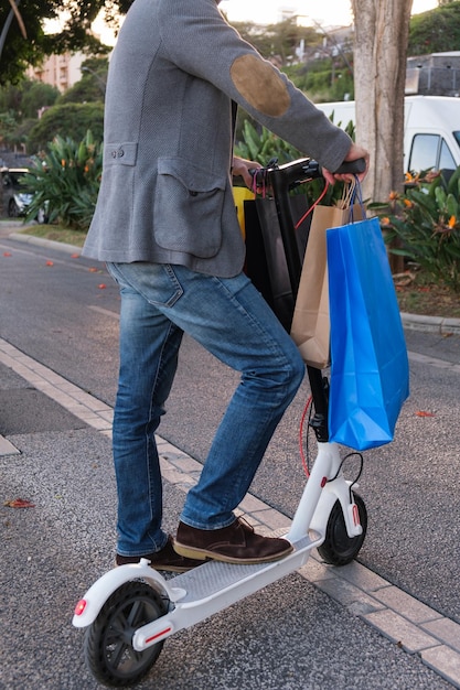 Uomo ben vestito che fa shopping sullo scooter elettrico