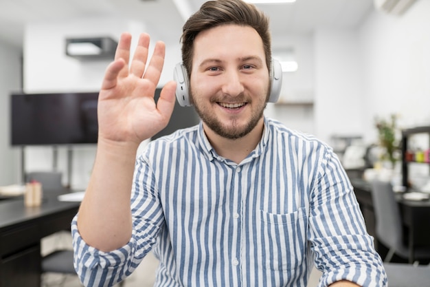 Uomo biondo caucasico con le cuffie che parla al computer