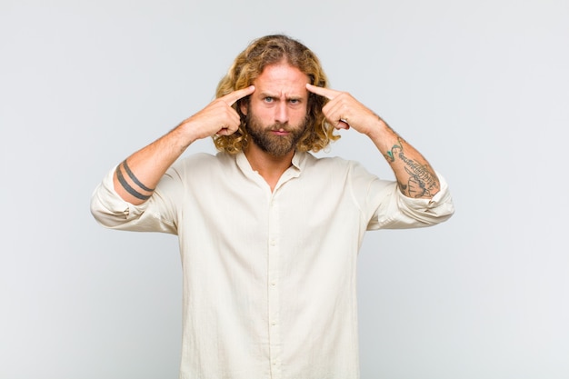 Uomo biondo con uno sguardo serio e concentrato, che fa brainstorming e pensa a un problema impegnativo