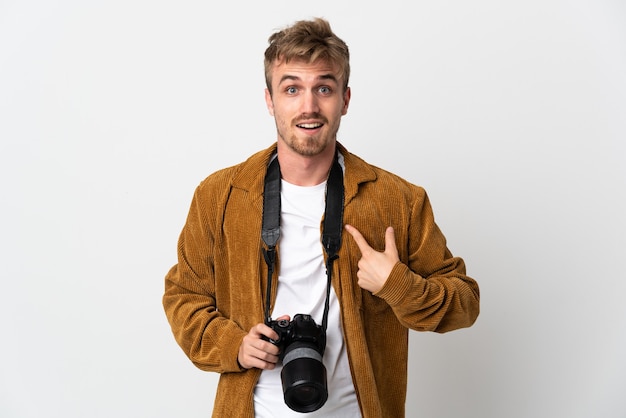 Uomo biondo del giovane fotografo isolato su bianco con l'espressione facciale di sorpresa