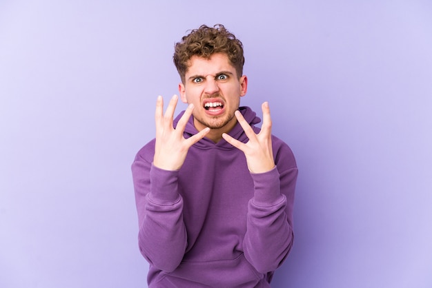 Uomo biondo giovane dei capelli ricci turbato che grida con le mani tese