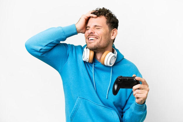 Uomo brasiliano che gioca con un controller per videogiochi su sfondo bianco isolato sorridendo molto
