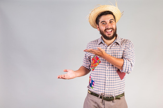 Uomo brasiliano che indossa abiti da festa junina Arraial Festa di San Giovanni che presenta un prodotto o una pubblicità sul lato