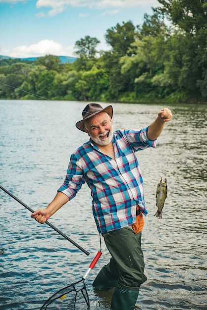 Uomo brutale in piedi nella pesca fluviale mentre le vacanze si rilassano in un ambiente naturale pesca con la mosca di successo ...