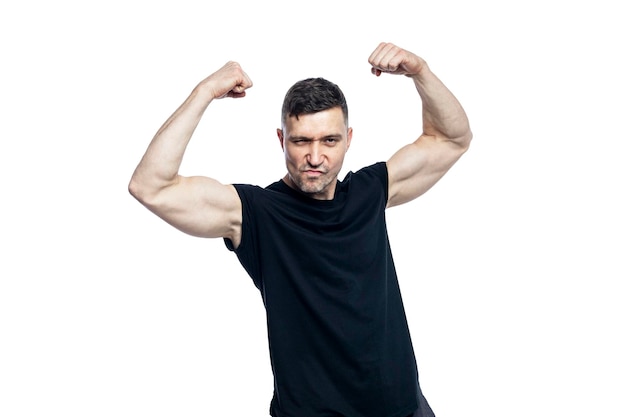 Uomo brutale sorridente con una maglietta nera mostra grandi muscoli sulle braccia Sport e stile di vita attivo Isolato su uno sfondo bianco
