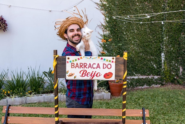 Uomo Caipira con gatto bianco nella tenda del bacio di traduzione brasiliana del June Party