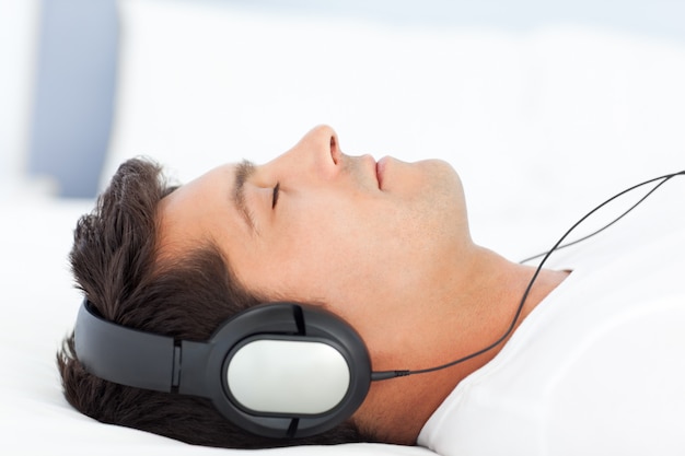 Uomo calmo che ascolta musica sul suo letto