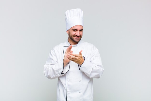 Uomo calvo che si sente felice e di successo, sorridente e battendo le mani, dicendo congratulazioni con un applauso