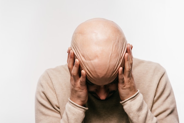 Uomo calvo che tiene la testa in stress psicologico