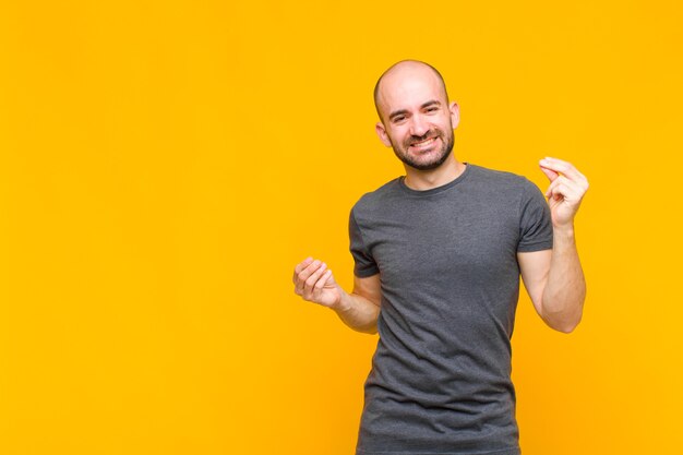 Uomo calvo sorridente, sentirsi spensierato, rilassato e felice, ballare e ascoltare musica, divertirsi a una festa