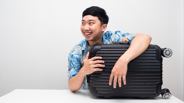 Uomo camicia blu con bagagli smling e guardando lo spazio della copia pensando al viaggio di vacanza