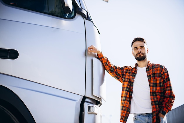 Uomo camionista felice in piedi vicino al camion