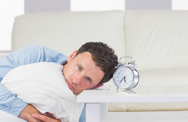Uomo casuale disturbato che riposa testa sul tavolo