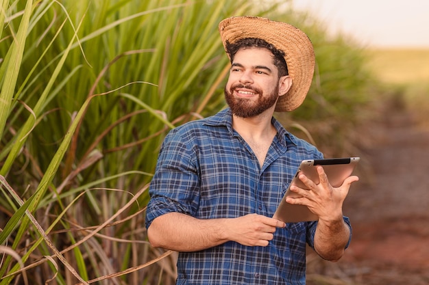 Uomo caucasico brasiliano agricoltore lavoratore rurale ingegnere agricolo azienda tablet e guardando il cielo Agricoltura e tecnologia