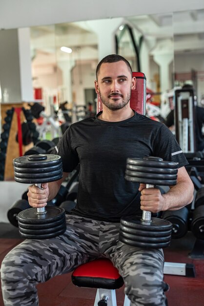 Uomo caucasico che fa allenamento con manubri in palestra