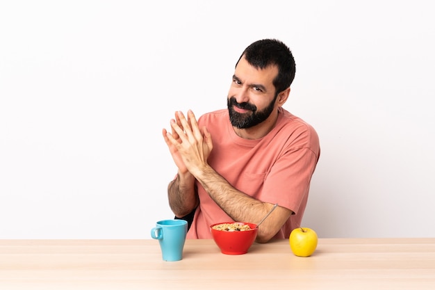 Uomo caucasico che mangia prima colazione in una tabella che trama qualcosa.