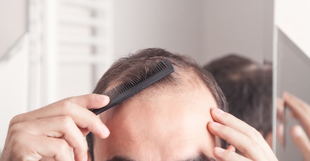 Uomo caucasico che pettina i capelli.