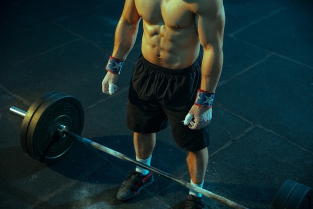 Uomo caucasico che pratica sollevamento pesi in palestra Modello sportivo maschio caucasico in posa