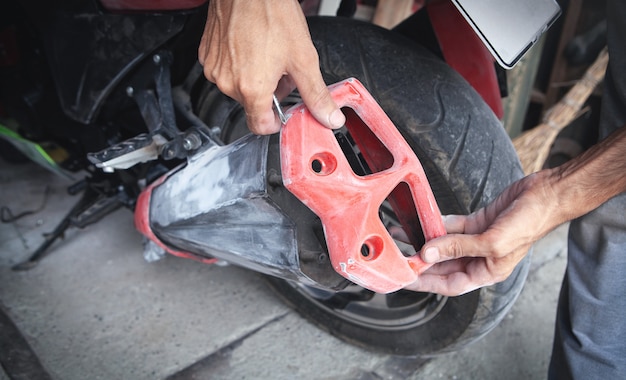 Uomo caucasico che ripara la sua moto in garage.