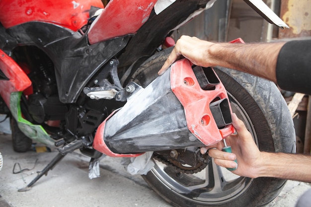 Uomo caucasico che ripara la sua moto in garage