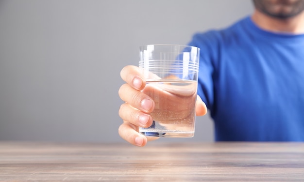 Uomo caucasico che tiene bicchiere d'acqua.