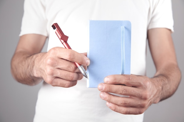 Uomo caucasico che tiene blocco note e penna in ufficio.