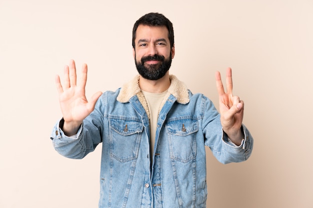 Uomo caucasico con la barba che conta sette con le dita