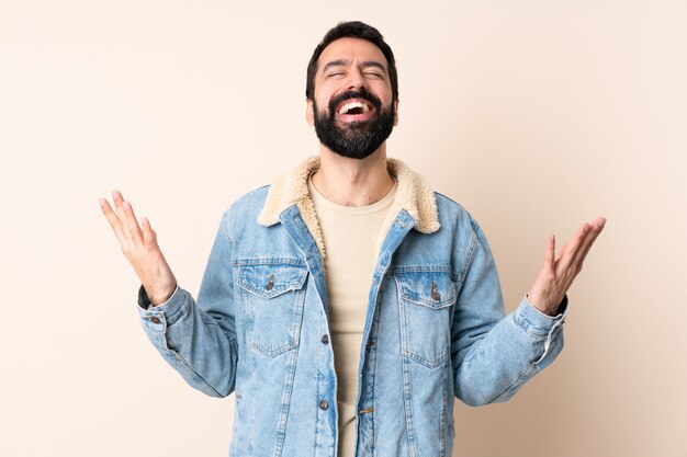 Uomo caucasico con la barba sopra la parete che sorride molto