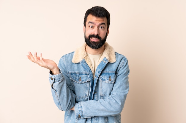 Uomo caucasico con la barba sopra lo spazio isolato con dubbi