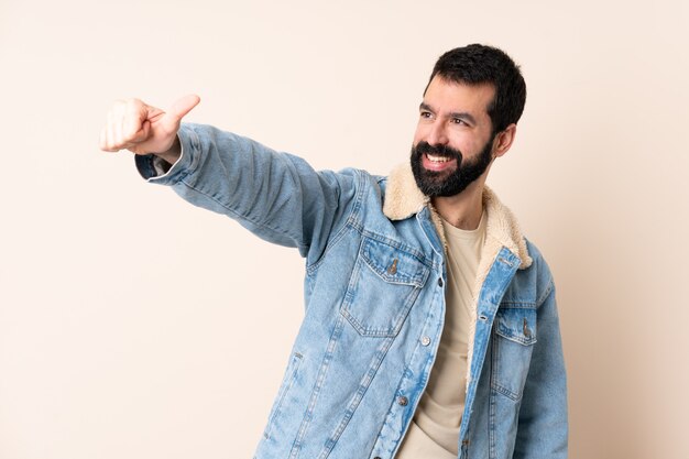 Uomo caucasico con la barba su sfondo isolato che dà un pollice in alto gesto