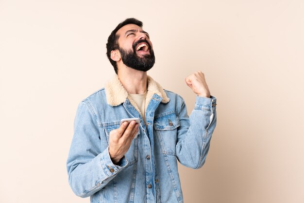 Uomo caucasico con la barba sul muro sorpreso e l'invio di un messaggio