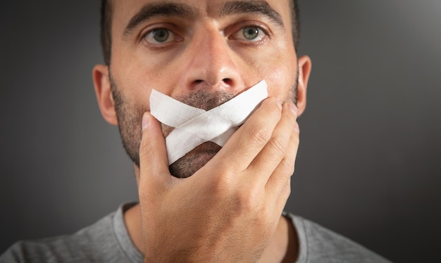 Uomo caucasico con nastro adesivo sulla bocca Censura