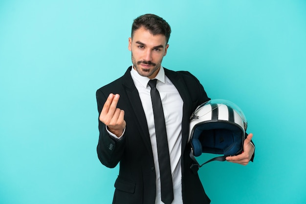 Uomo caucasico d'affari con casco da moto isolato su sfondo blu che fa gesto di denaro