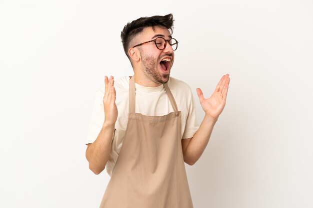 Uomo caucasico del cameriere del ristorante isolato su fondo bianco con l'espressione facciale di sorpresa