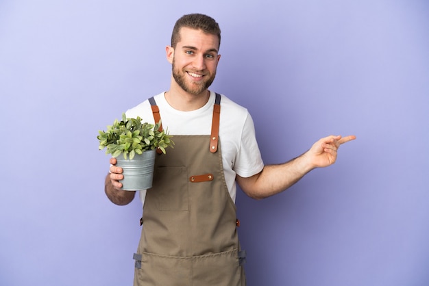 Uomo caucasico del giardiniere che tiene una pianta isolata